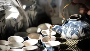 Traditionelle chinesische Teeschale und Keramikgefäß auf einem eleganten Holztisch präsentiert.