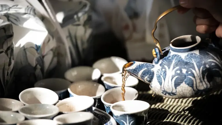 Traditionelle chinesische Teeschale und Keramikgefäß auf einem eleganten Holztisch präsentiert.