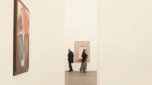 Zwei Personen betrachten Kunstwerke in einer modernen Galerie in Deutschland.