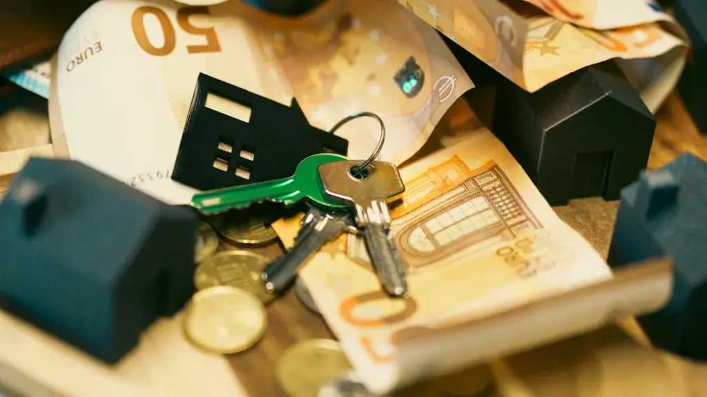 Hausschlüssel liegen auf Euro-Banknoten neben einem Modellhaus für Immobilienfinanzierung.