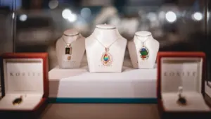 Präsentierte Schmuckstücke auf weißen Ständern in einer eleganten Vitrine im Museum.