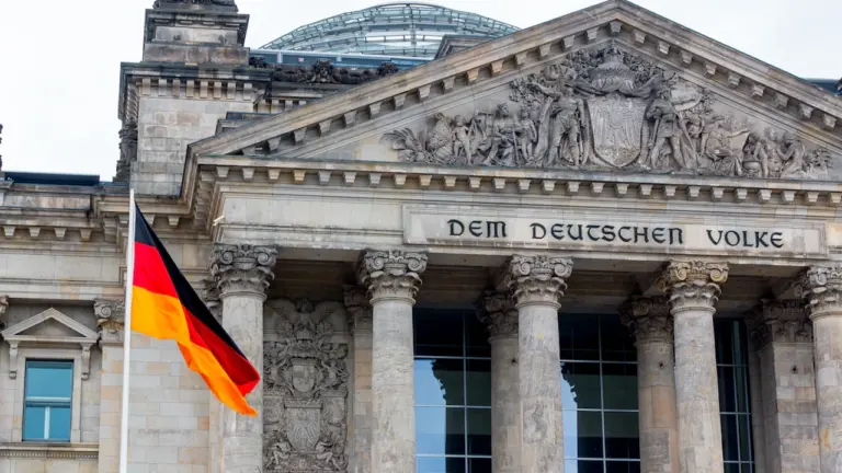 Die deutsche Flagge weht vor dem historischen Reichstagsgebäude in Berlin, Deutschland.