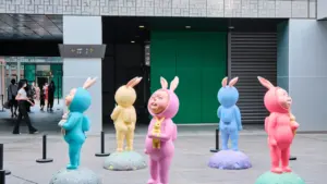 Bunte Hasen-Figuren bei einer Ausstellung im modernen Innenhof eines Museums.