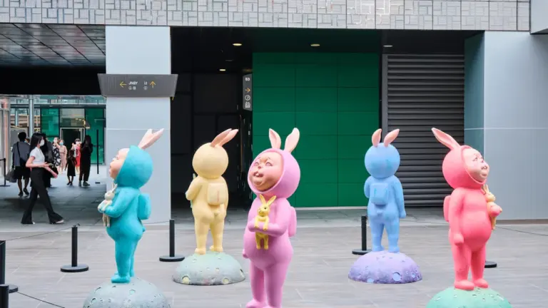Bunte Hasen-Figuren bei einer Ausstellung im modernen Innenhof eines Museums.