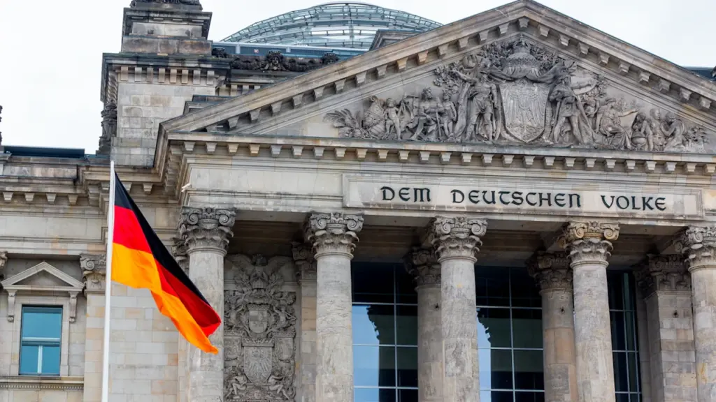 Die deutsche Flagge weht stolz vor dem historischen Reichstagsgebäude in Berlin.
