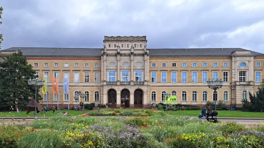 Prachtvolles Gebäude in Karlsruhe, nachts stimmungsvoll mit bunten Lichtern illuminiert.