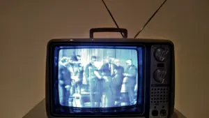 Klassischer Röhrenfernseher zeigt eine historische Schwarz-Weiß-Übertragung auf einem hellen Untergrund.