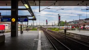 Moderner Bahnsteig mit Gleisen an einem deutschen Bahnhof bei Tageslicht.