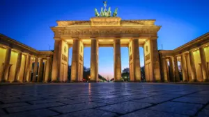 Das Brandenburger Tor in Berlin bei Nacht vor tiefblauem Himmel.