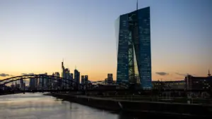 Die Europäische Zentralbank in Frankfurt am Main bei stimmungsvollem Sonnenuntergang über der Skyline.