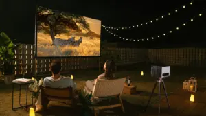 Ein Paar genießt abends einen Film bei einem privaten Open-Air-Kino im Garten.