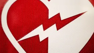 Ein rotes Herz-Symbol mit einem Blitz, das für medizinische Erste-Hilfe-Kurse steht.