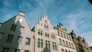 Historische Gebäude mit Giebeln in einer deutschen Stadt bei strahlend blauem Himmel.