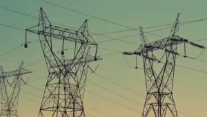 Strommasten ragen vor einem bewölkten Himmel auf und symbolisieren die Energieinfrastruktur in Deutschland.