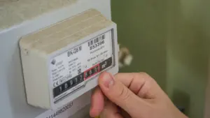 Eine Hand prüft einen Stromzähler, um den aktuellen Energieverbrauch für die Abrechnung abzulesen.