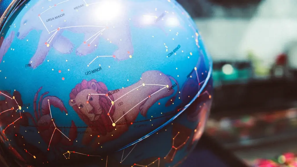 Ein beleuchteter Globus mit Sternbildern und astrologischen Symbolen für die tägliche Vorhersage.