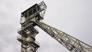 Ein historisches Fördergerüst einer Zeche als Symbol für die Dortmunder Bergbaugeschichte vor grauem Himmel.