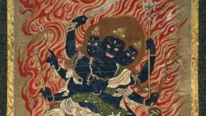 Eine dreiköpfige, dunkelblaue buddhistische Gottheit mit vielen Armen vor einem Hintergrund aus Flammen.