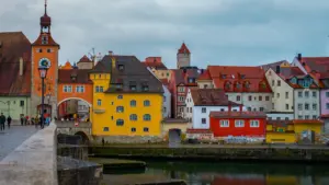 Historische Altstadt von Regensburg an der Donau mit traditionellen farbenfrohen Gebäuden und Brücke.