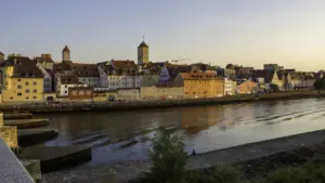 Die Steinerne Brücke in Regensburg in der goldenen Abendstimmung über der Donau.