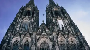 Der Kölner Dom erstrahlt malerisch in der Abenddämmerung am Rheinufer.