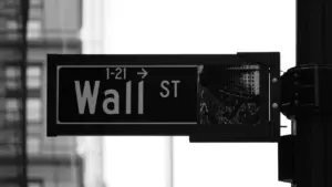 Schwarz-Weiß-Aufnahme eines Straßenschildes mit der Aufschrift Wall Street in New York City.